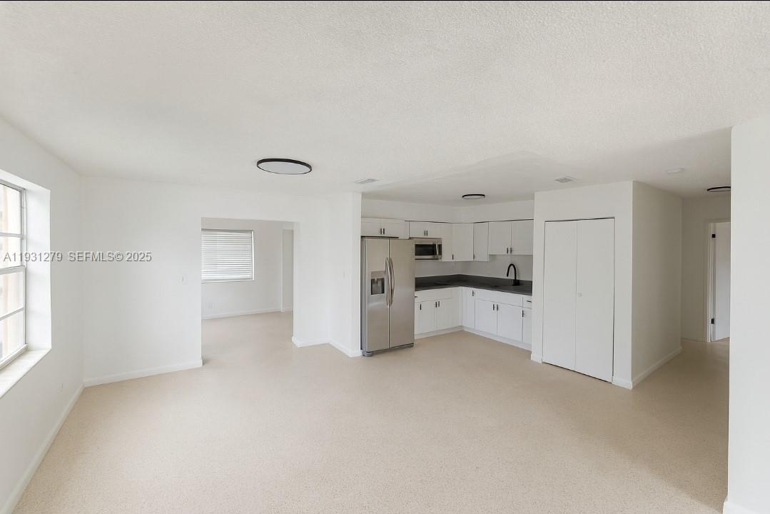 141 West 31st Street Hialeah, FL 33012 - Photo 3 of 9 a view of a kitchen with refrigerator and white cabinets
