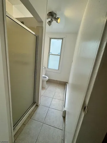 a bathroom with a granite countertop shower and a toilet