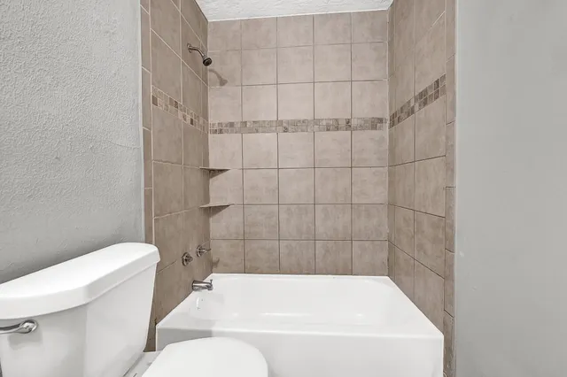 a bathroom with a bathtub and toilet