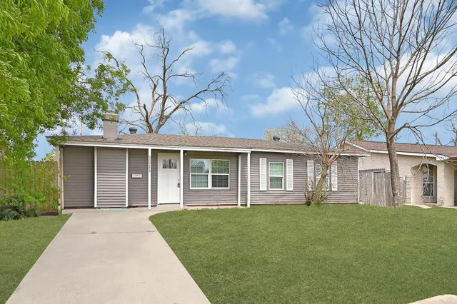 a front view of a house with a garden and yard