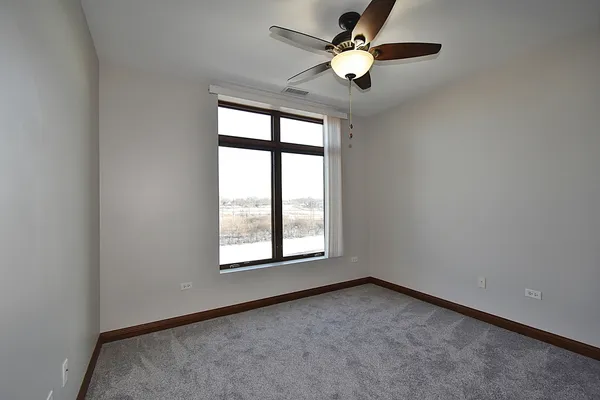 an empty room with a window and a fan