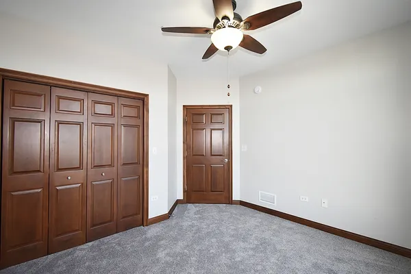 an empty room with closet and windows