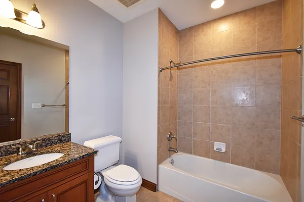 a bathroom with a granite countertop sink toilet and shower