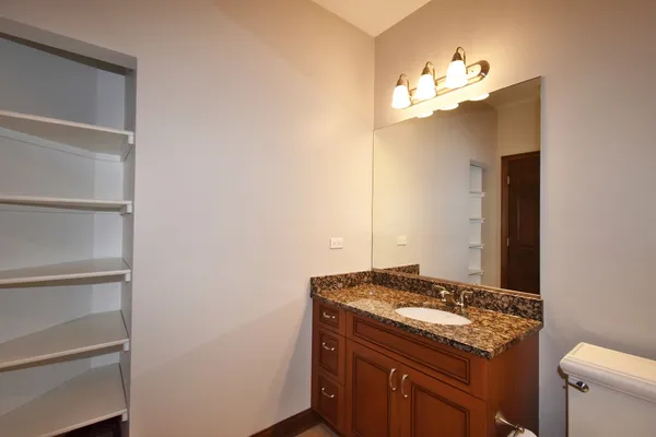 a bathroom with a granite countertop sink and a mirror