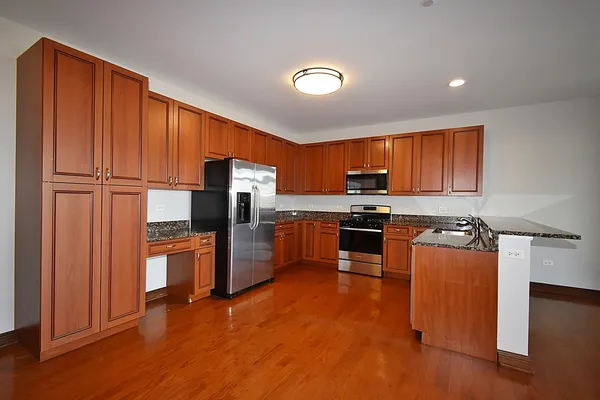 a kitchen with stainless steel appliances granite countertop a refrigerator stove and oven