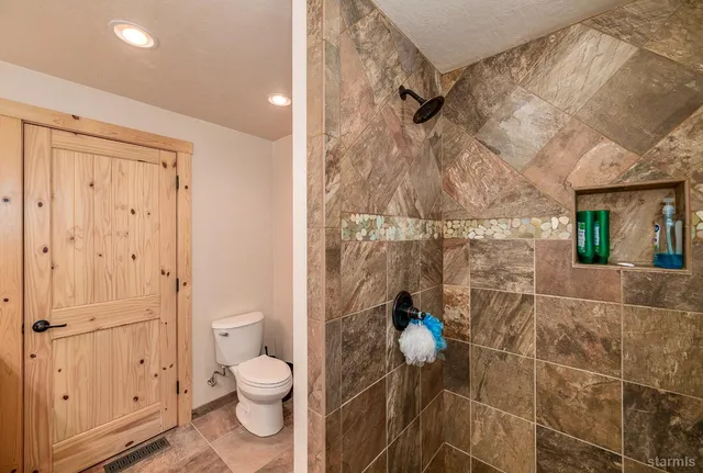 a bathroom with a toilet and a shower