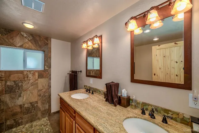a bathroom with double vanity sink and a mirror
