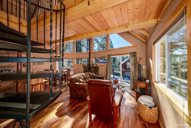 a view of a patio with couches table chairs and wooden floor