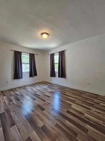 a view of wooden floor and windows in a room