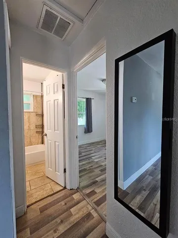 a view of a hallway with wooden floor and front door