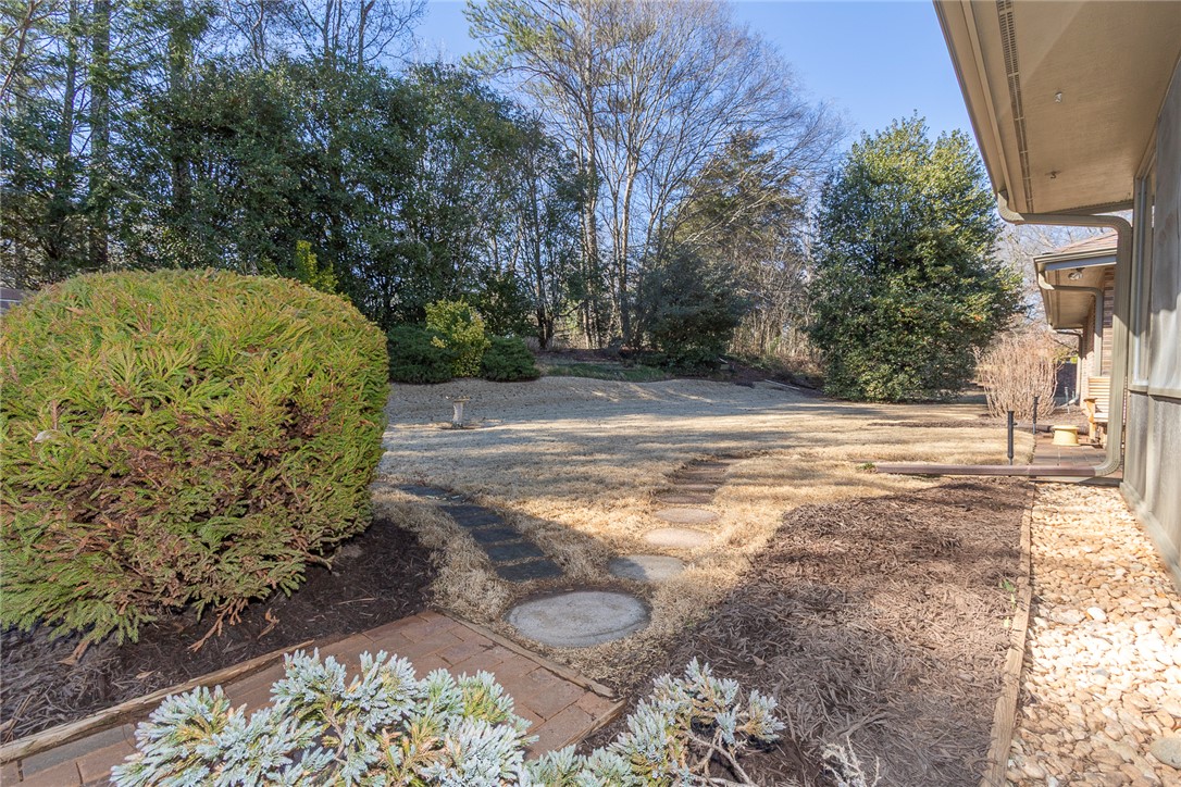 52 Hickory Way Clemson, SC 29631 - Photo 40 of 49 This tranquil yard features a meandering stone path, surrounded by mature trees and lush landscaping.