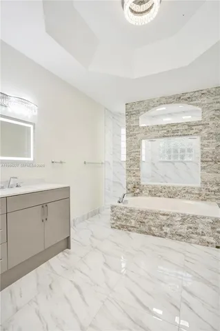 a large white kitchen with a large window and stainless steel appliances