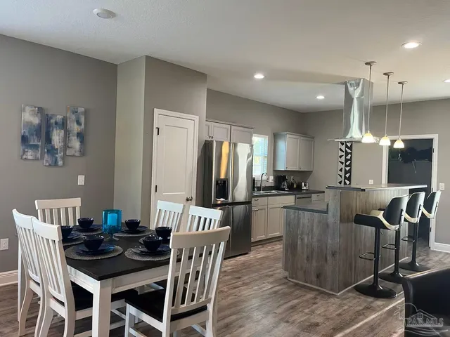 a kitchen with a table chairs refrigerator and microwave