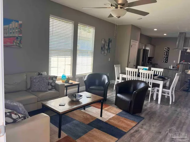 a living room with furniture and a wooden floor