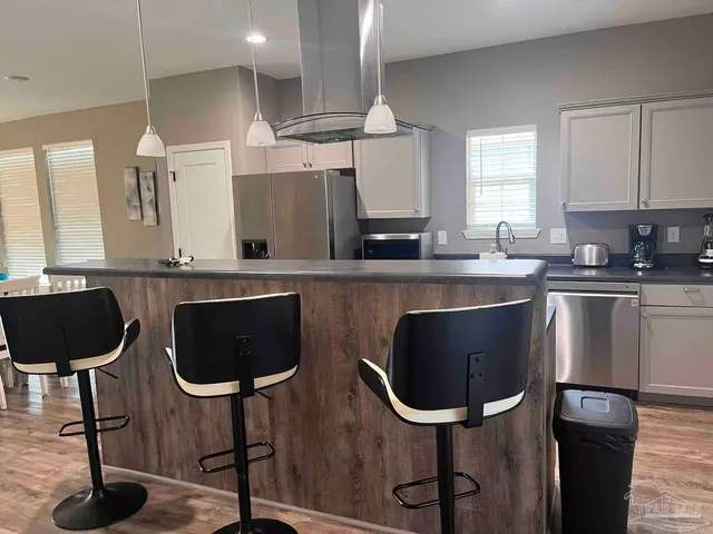 a kitchen with stainless steel appliances granite countertop a sink a stove a refrigerator and cabinets