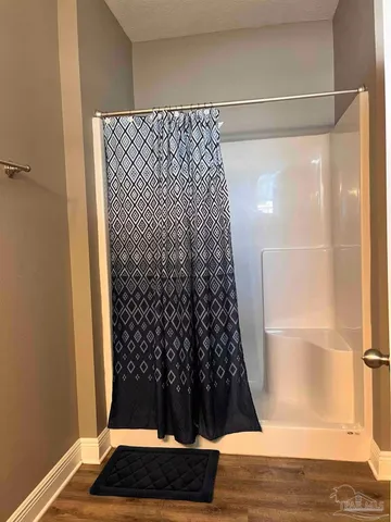 a bathroom with a toilet and a shower curtain