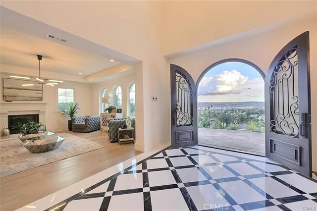 a living room with furniture a fireplace and a chandelier