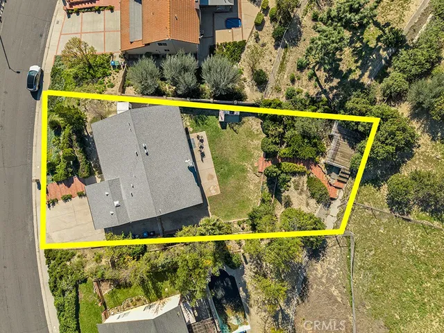 an aerial view of residential houses with outdoor space and trees