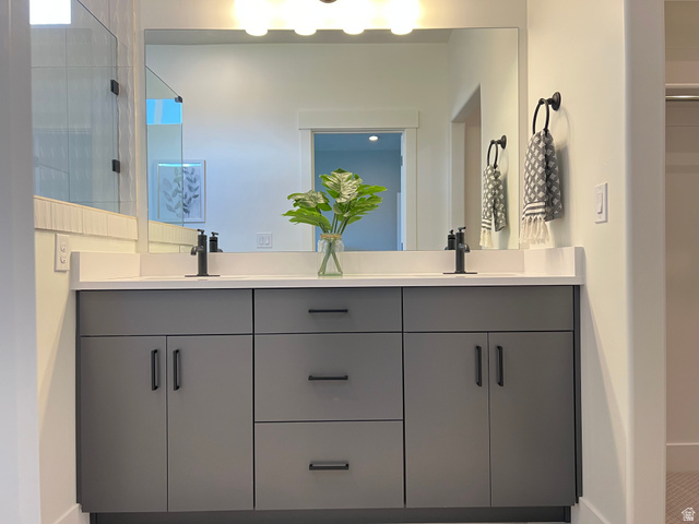1951 2900 West Provo, UT 84601 - Photo 15 of 21 Dual vanity featuring a light countertop and dark cabinetry with matte black hardware