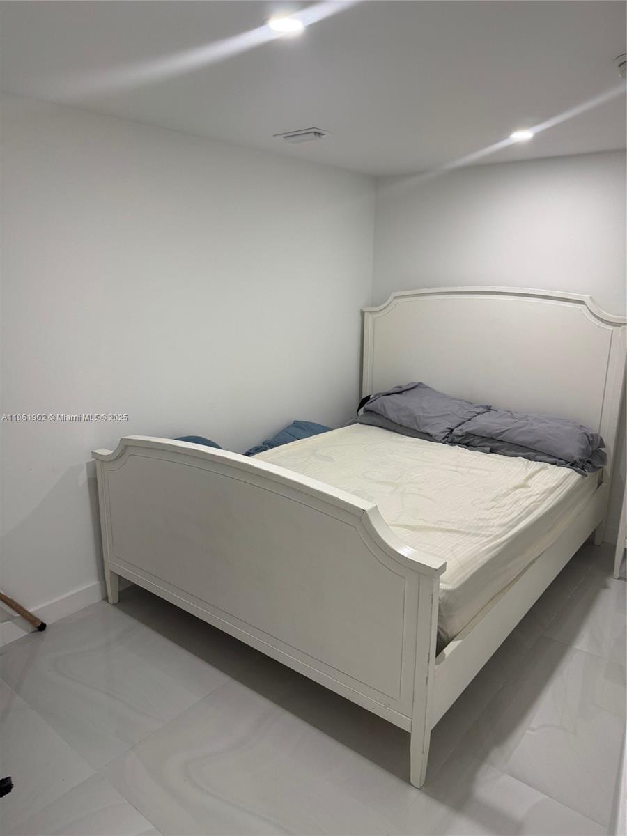 6423 Collins Avenue, Unit 401 Miami Beach, FL 33141 - Photo 13 of 17 a bed sitting in a bedroom next to a window