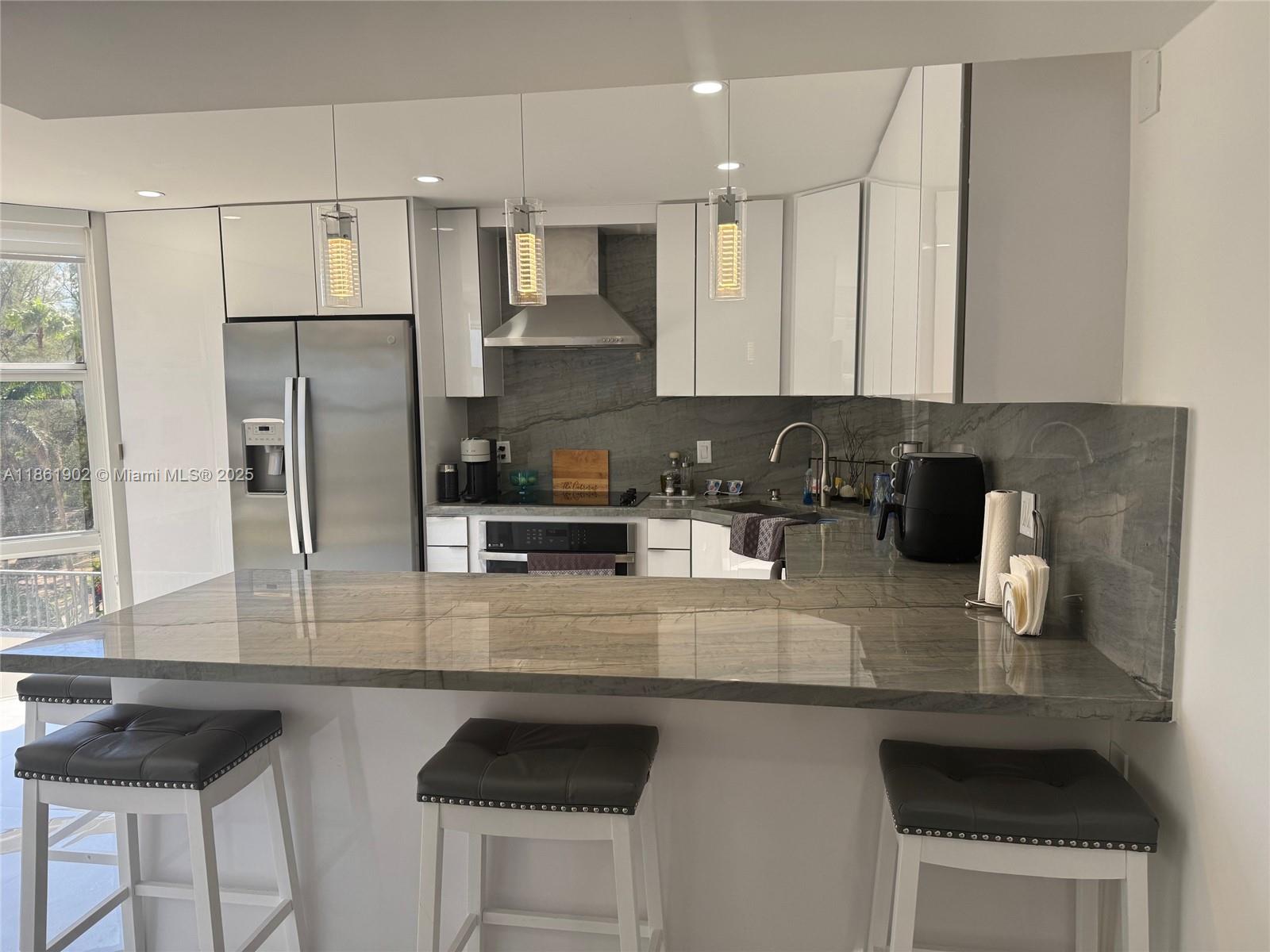 6423 Collins Avenue, Unit 401 Miami Beach, FL 33141 - Photo 6 of 17 a kitchen with stainless steel appliances granite countertop a sink refrigerator and cabinets