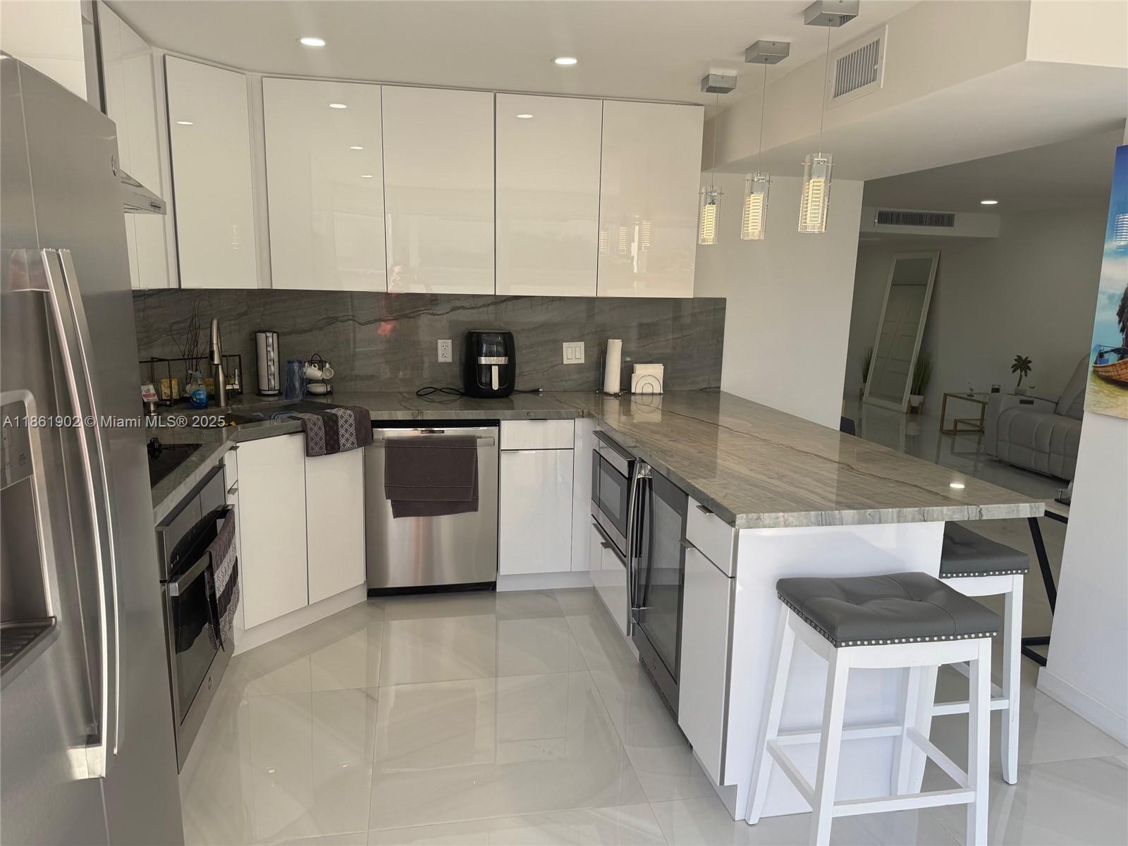6423 Collins Avenue, Unit 401 Miami Beach, FL 33141 - Photo 9 of 17 a kitchen with a stove a sink and a refrigerator