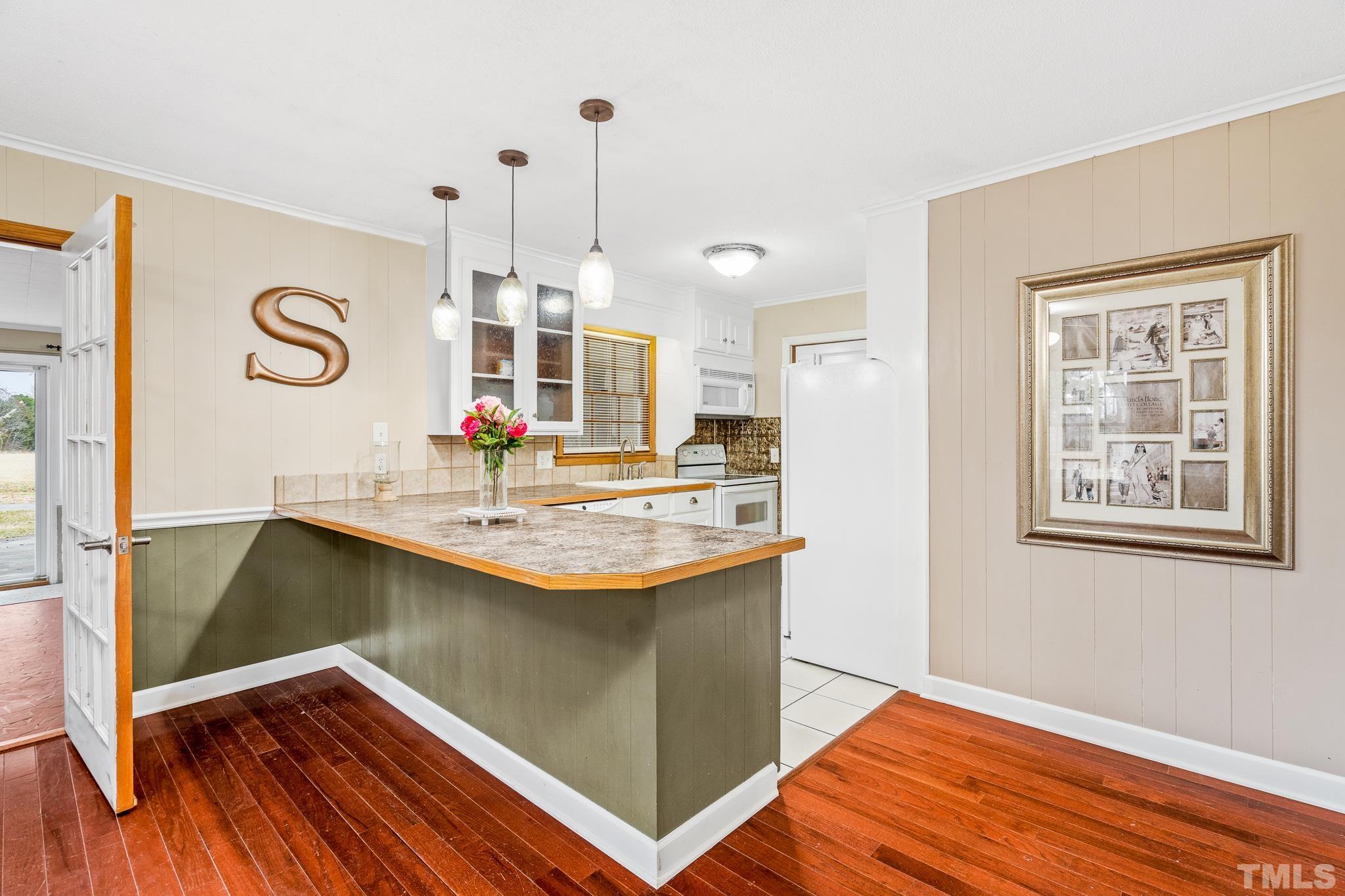 7630 High Rock Road Efland, NC 27243 - Photo 7 of 25 a kitchen with stainless steel appliances granite countertop a sink and a wooden floor