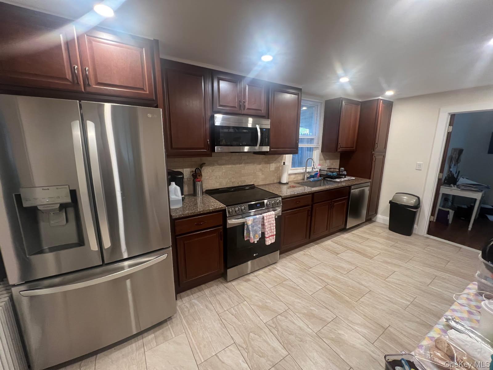 a kitchen with stainless steel appliances granite countertop a refrigerator stove and sink