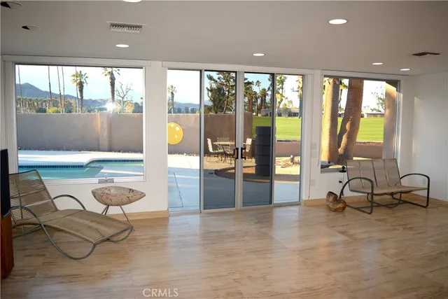 a living room with furniture and large windows