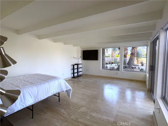 a spacious bedroom with a bed and glass door