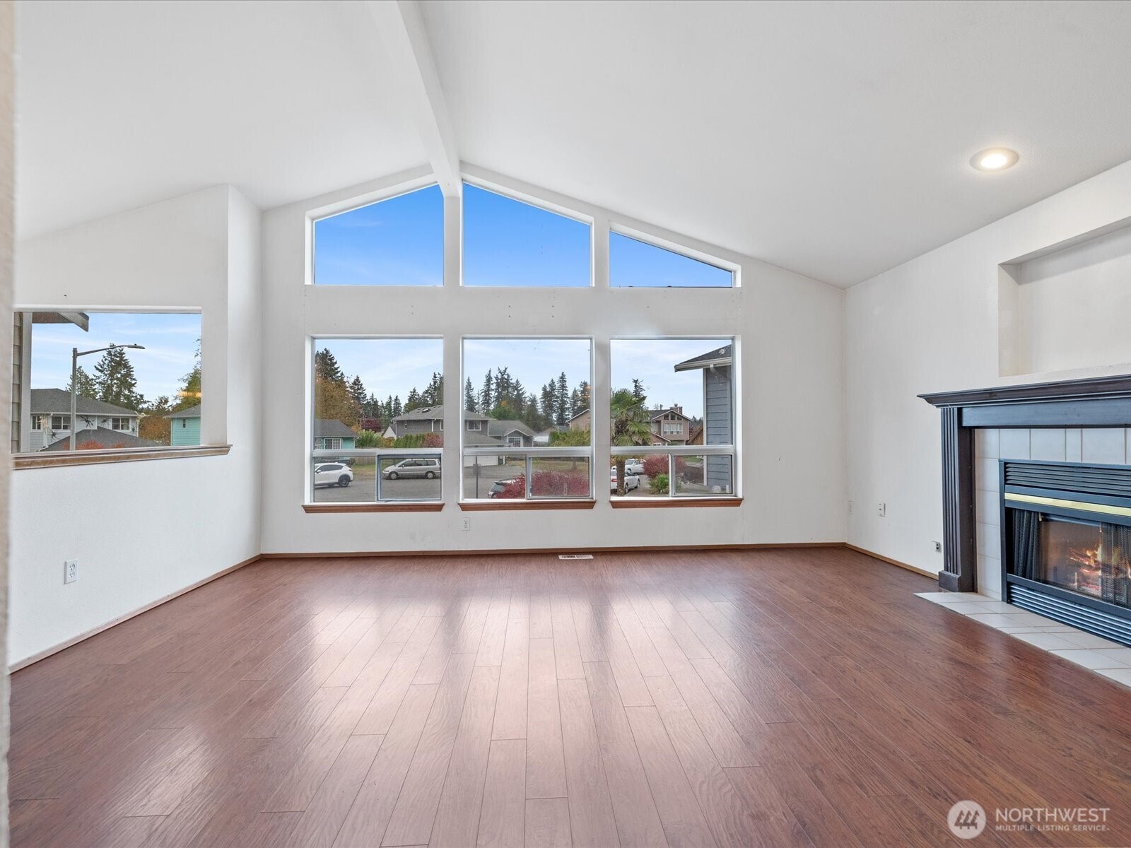 5411 158th Place Southwest Edmonds, WA 98026 - Photo 6 of 38 an empty room with wooden floor fireplace and windows