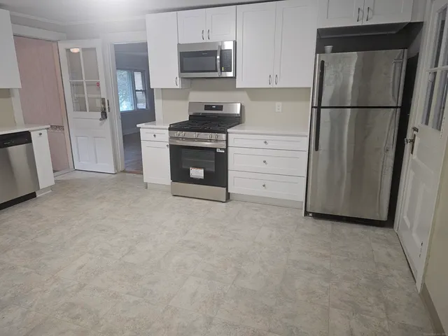 a kitchen with white cabinets and stainless steel appliances