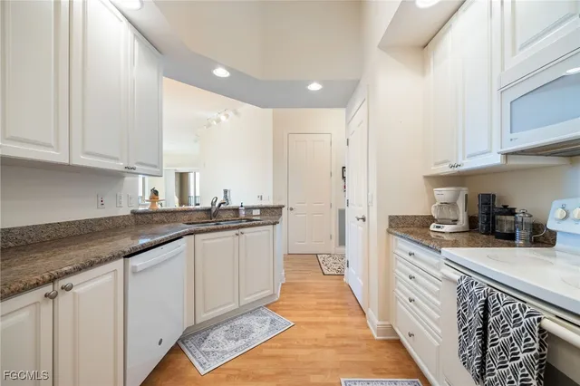 a kitchen with granite countertop a sink and cabinets