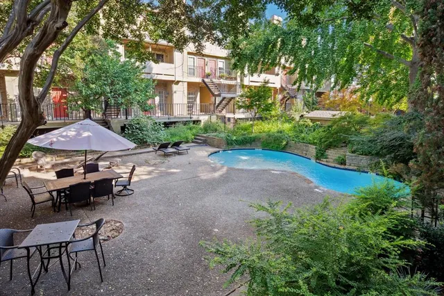 a view of a patio with table and chairs under an umbrella