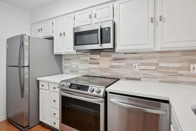 a kitchen with stainless steel appliances white cabinets and a stove