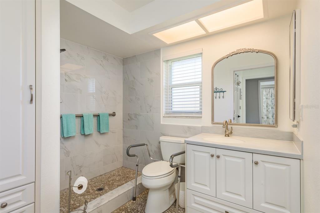 409 Stirling Terrace Dunedin, FL 34698 - Photo 11 of 17 a bathroom with a sink a toilet and mirror