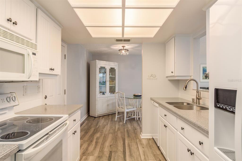 409 Stirling Terrace Dunedin, FL 34698 - Photo 7 of 17 a kitchen with stainless steel appliances granite countertop a sink stove and cabinets