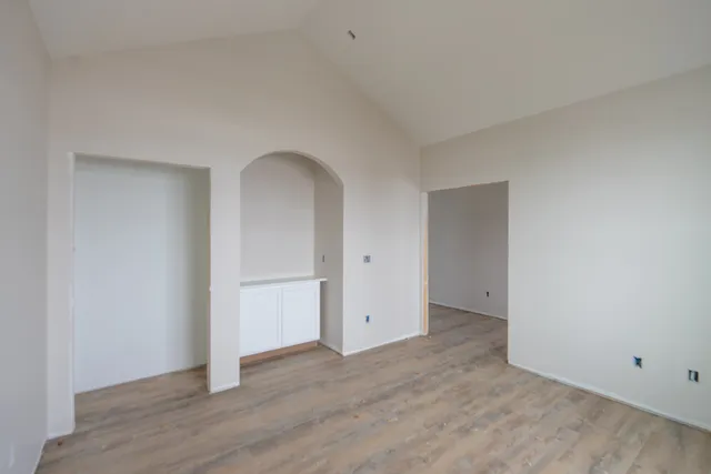 a view of a kitchen with a sink dishwasher wooden cabinets and entryway