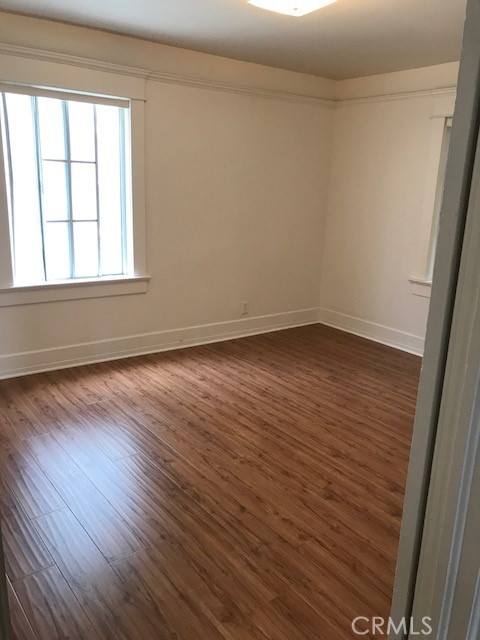 1624 South Gramercy Place Los Angeles, CA 90019 - Photo 18 of 20 wooden floor in an empty room with a window