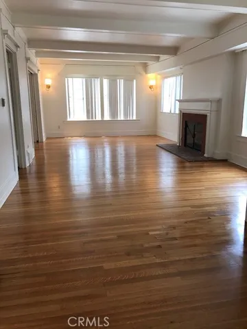 a view of empty room with wooden floor and fireplace