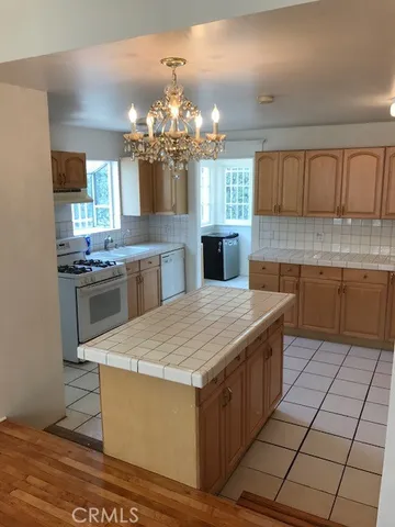 a kitchen with kitchen island granite countertop a sink counter top space and cabinets
