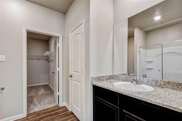 a bathroom with a granite countertop sink and a mirror