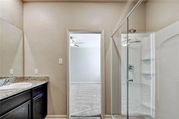 a bathroom with a granite countertop sink mirror and shower