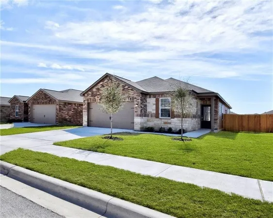 a front view of a house with a garden and yard