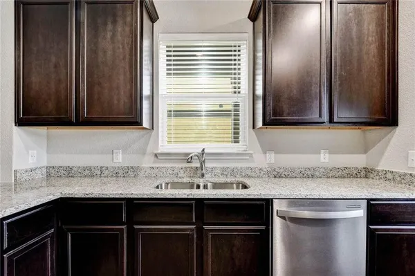 a kitchen with granite countertop cabinets sink and window