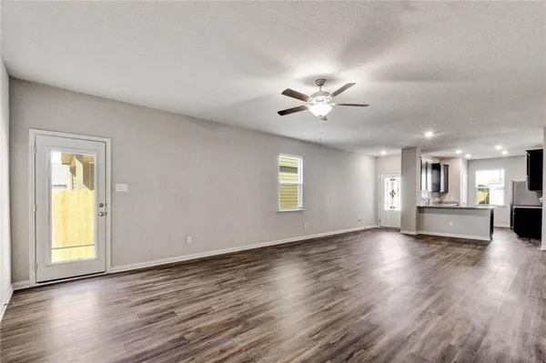 a view of an empty room with window and wooden floor