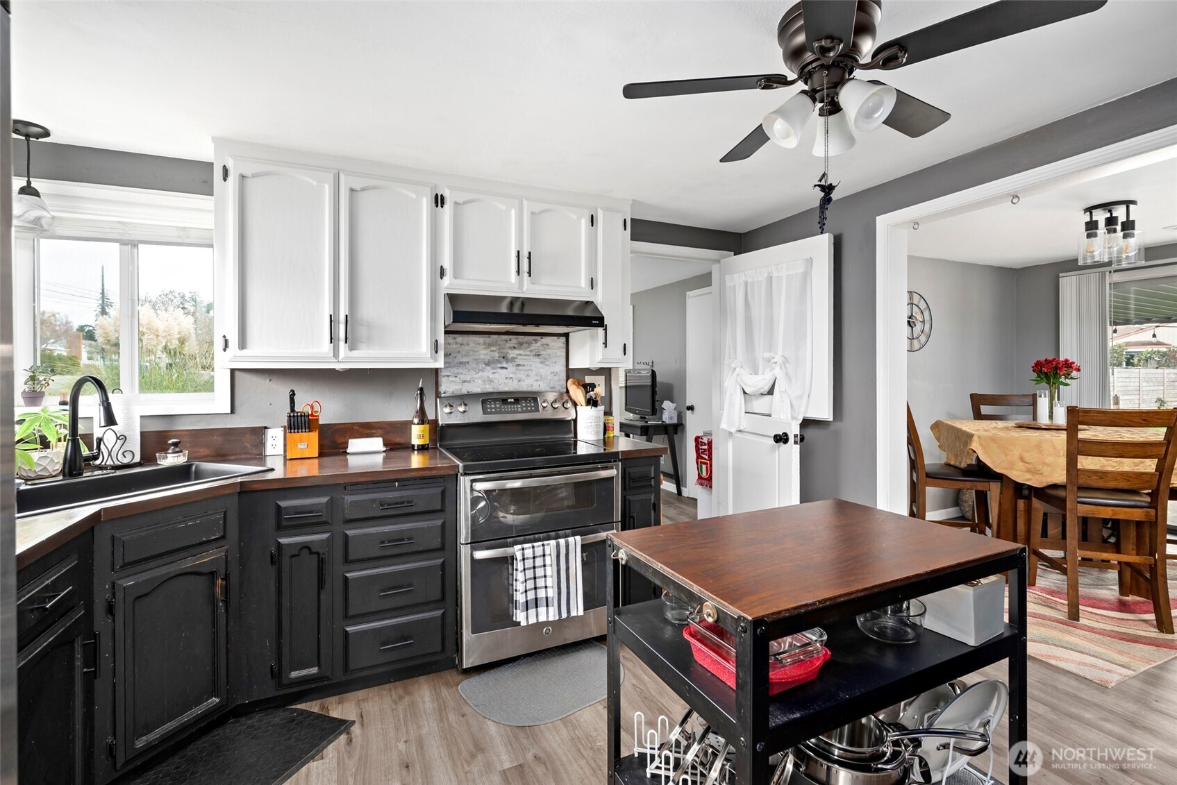 541 Southeast 5th Avenue Oak Harbor, WA 98277 - Photo 11 of 35 a kitchen with a stove a sink dishwasher a dining table and chairs with wooden floor