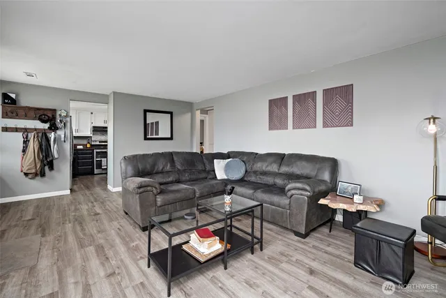 a living room with furniture and a wooden floor