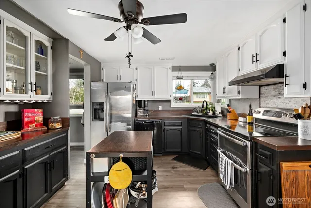 a kitchen with stainless steel appliances granite countertop a stove refrigerator and cabinets