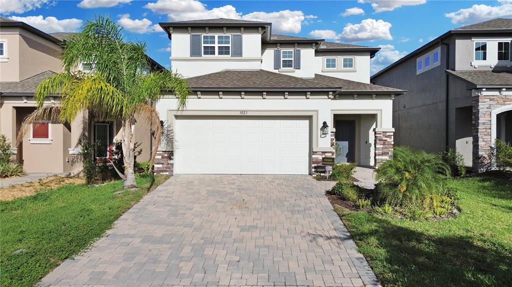 3023 Adams Cross Drive Zephyrhills, FL 33540 - Photo 2 of 36 a front view of a house with a yard and garage